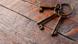 Três velhas chaves de esqueleto colocadas sobre uma velha mesa de madeira.