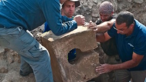Os escavadores removem uma toalete de pedra que foi usada para contaminar o santuário onde o altar foi encontrado.
