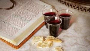 Uma Bíblia aberta, vinho de Páscoa e pedaços de pão asmo.
