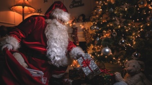 Papai Noel deixando presentes debaixo da árvore de Natal. 