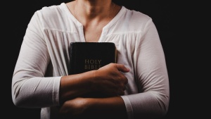 Uma mulher segurando a Bíblia.