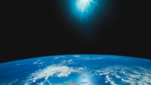 Photo illustration of bright light above the earth.
