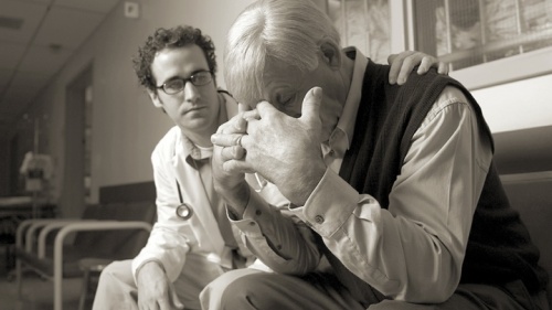Um médico consolando uma pessoa enlutada.