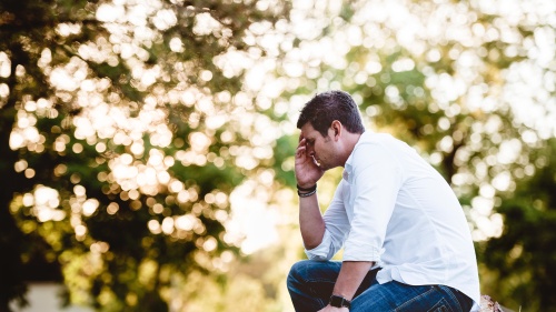 A man sitting and praying.