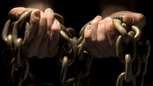 Hands hold heavy chains.