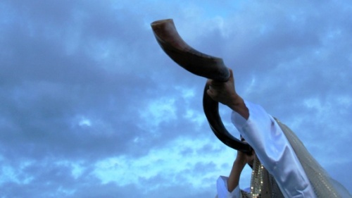Uma pessoa tocando um shofar.