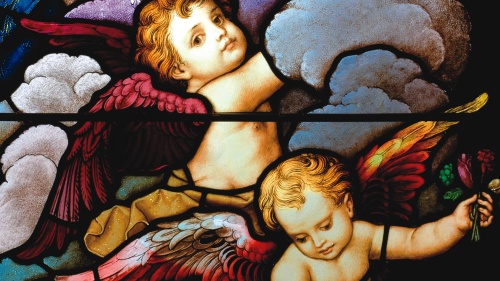 Stained glass close-up of two cherubic angels in the sky