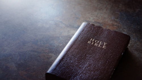 Uma bíblia sobre uma mesa castanha.