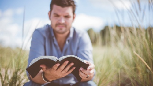 Um homem lendo uma Bíblia.