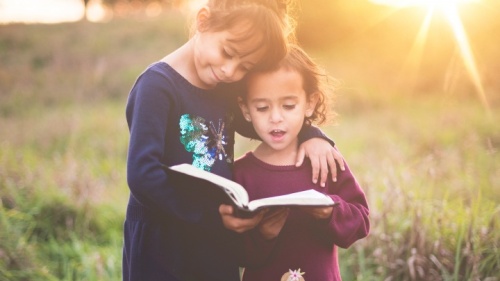 Duas moças lendo a Bíblia juntas.