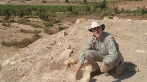 O autor examina um moedor de pedra e uma tigela no Tall el-Hammam antes do início das escavações. 