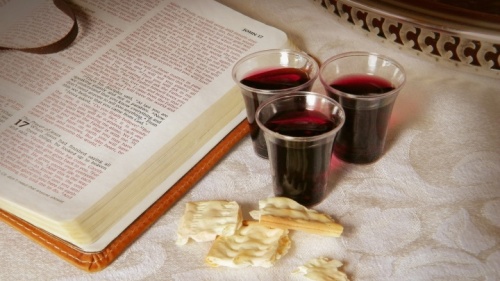 Uma Bíblia aberta, vinho de Páscoa e pedaços de pão asmo.