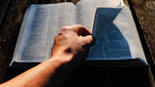 Um homem folheando uma Bíblia.