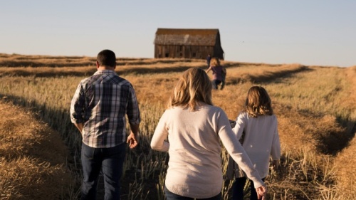 Uma família caminhando por um campo.