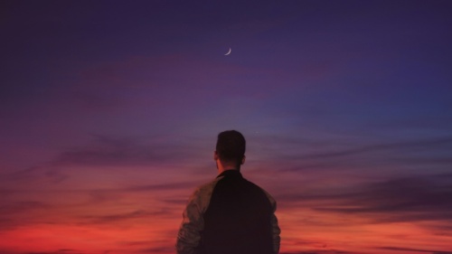 Uma pessoa olhando para o horizonte de um amanhecer.