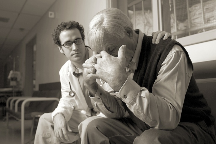 Um médico consolando uma pessoa enlutada.