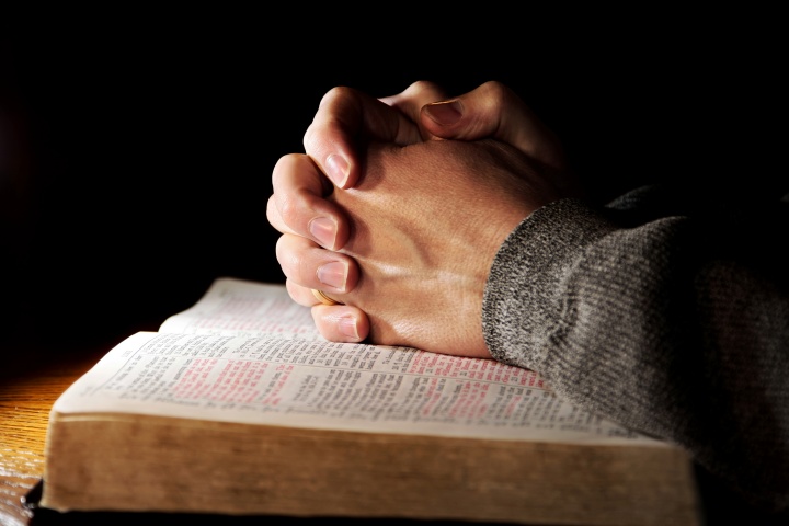 As mãos de um homem numa Bíblia.