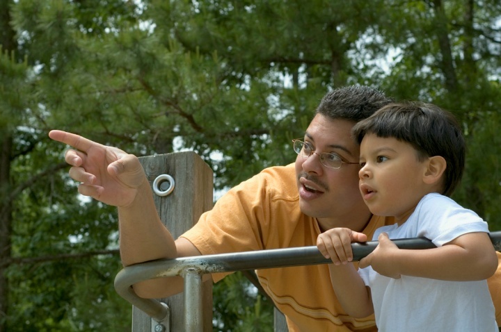 Pai e filho brincando em um parque.
