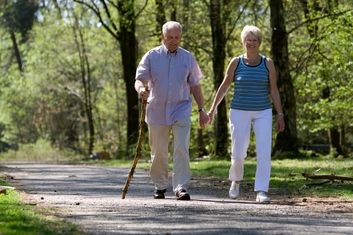 Um casal de idosos caminhando juntos.