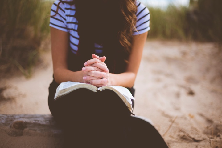 Uma mulher com uma Bíblia no colo.