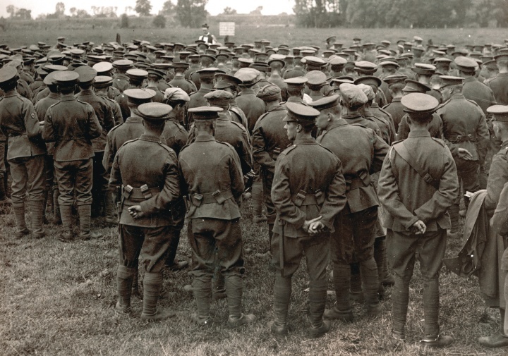 Uma fotografia velha de WWI que mostra uma missa no campo com os soldados que olham um padre.