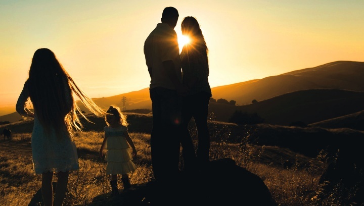 Uma família no campo ao pôr do sol.