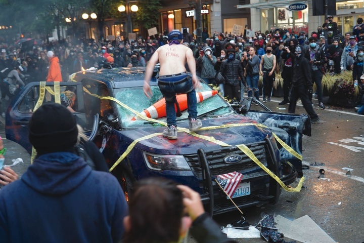 Manifestantes destroem um veículo da polícia em Seattle.