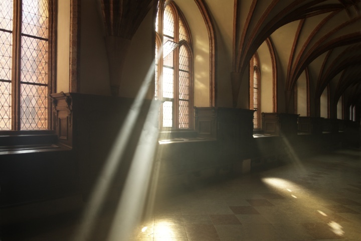 Raios de sol brilhando através das janelas duma velha igreja