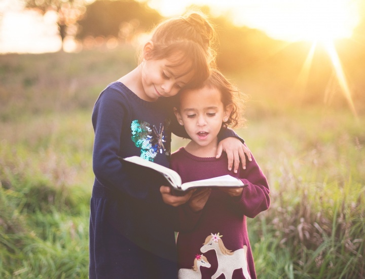Duas moças lendo a Bíblia juntas.