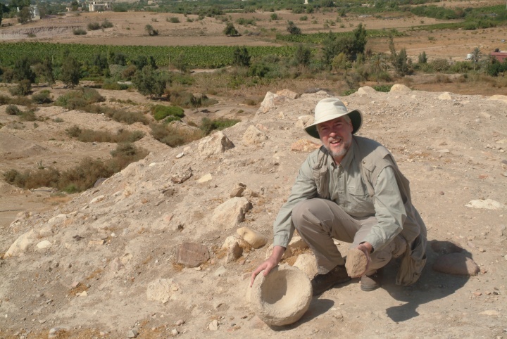 O autor examina um moedor de pedra e uma tigela no Tall el-Hammam antes do início das escavações. 
