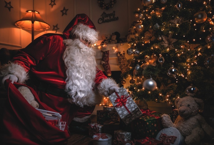 Papai Noel deixando presentes debaixo da árvore de Natal. 