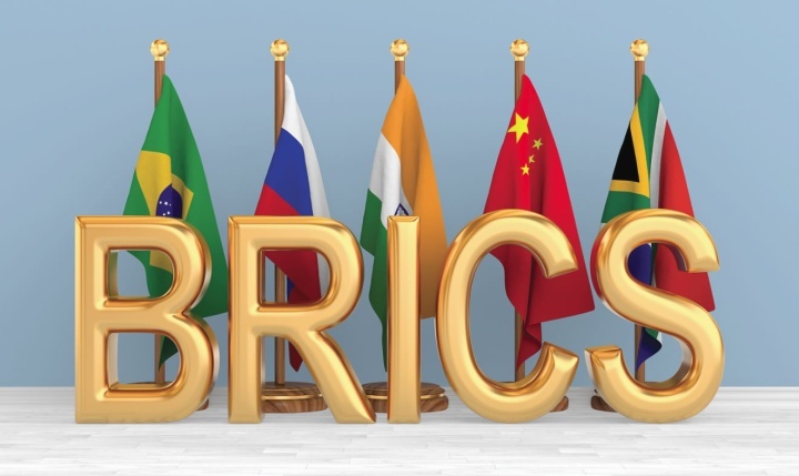 Letras da sigla BRICS com bandeiras dos países-membros ao fundo