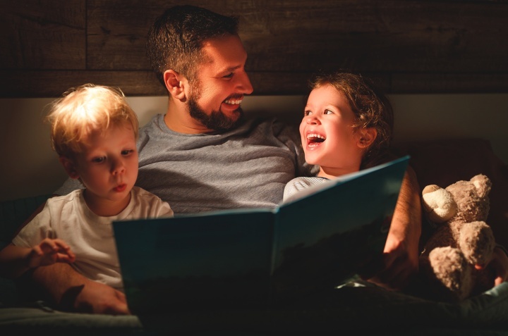 Um pai lendo um livro para seus filhos.
