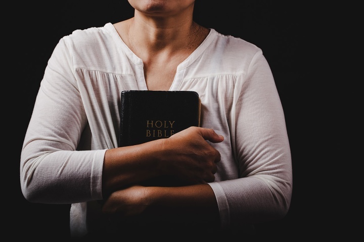 Uma mulher segurando a Bíblia.