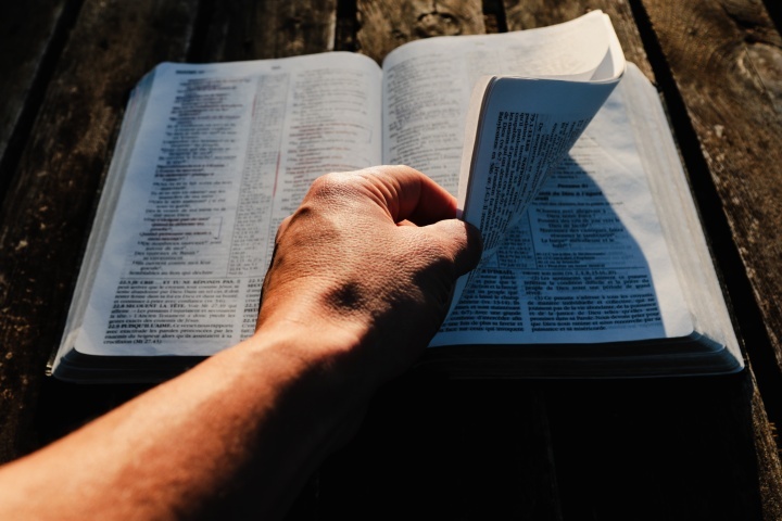 Um homem folheando uma Bíblia.