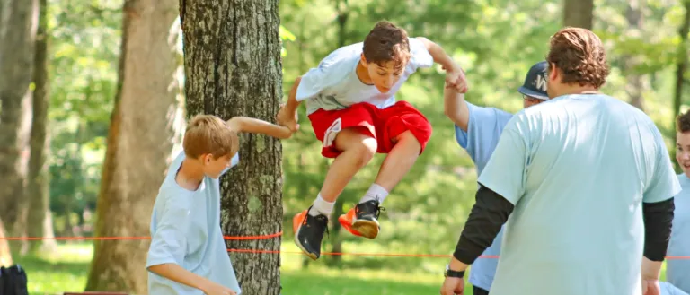 a boy jumping over a rope