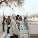 Uma mulher lendo a Bíblia perto de uma janela.