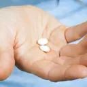 pills in womans open hand