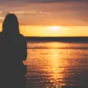 Uma pessoa que observando um pôr do sol.