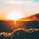 Um pôr-do-sol sobre colinas.