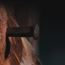 Uma antiga estaca de metal pregada a uma viga de madeira.