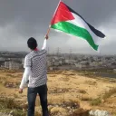 Um jovem com a bandeira da Palestina.