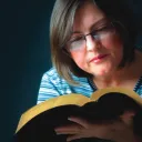 Uma mulher lendo uma Bíblia.