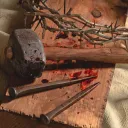 Martelo usado, pregos e espinhos.