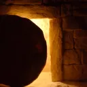 Pedra redonda em frente a um túmulo.