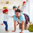 Um pai brincando com seus filhos.