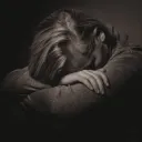 Uma mulher com a sua cabeça em seus braços.