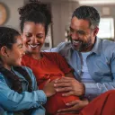 Uma família sentada em um sofá.