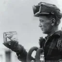 Um minerador segurando uma gaiola com um canário.