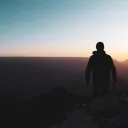 Uma pessoa parada no topo do Grand Canyon.